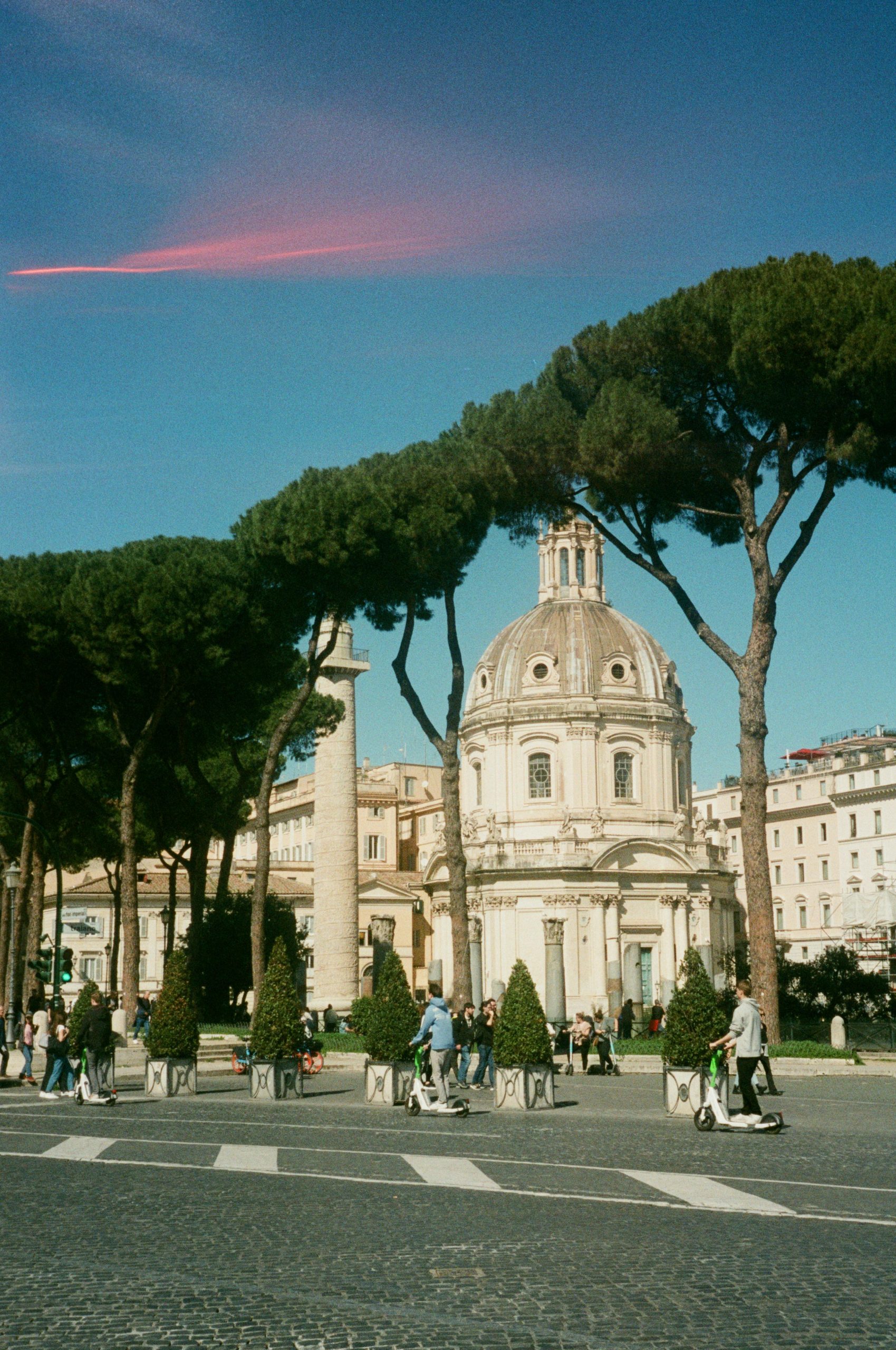 Stunning view of a Roman dome and historic architecture surrounded by tall Pini trees.