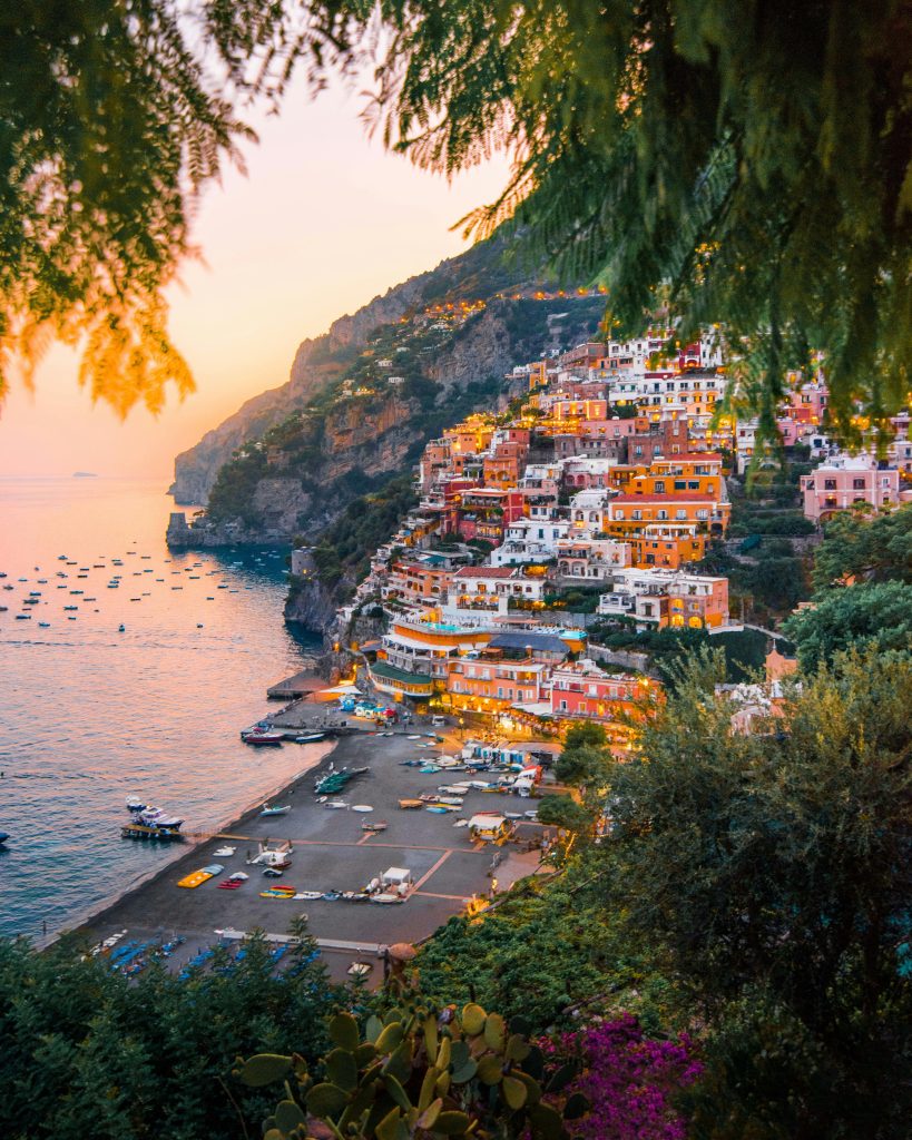 Breathtaking view of Positano's colorful cliffside homes at sunset.