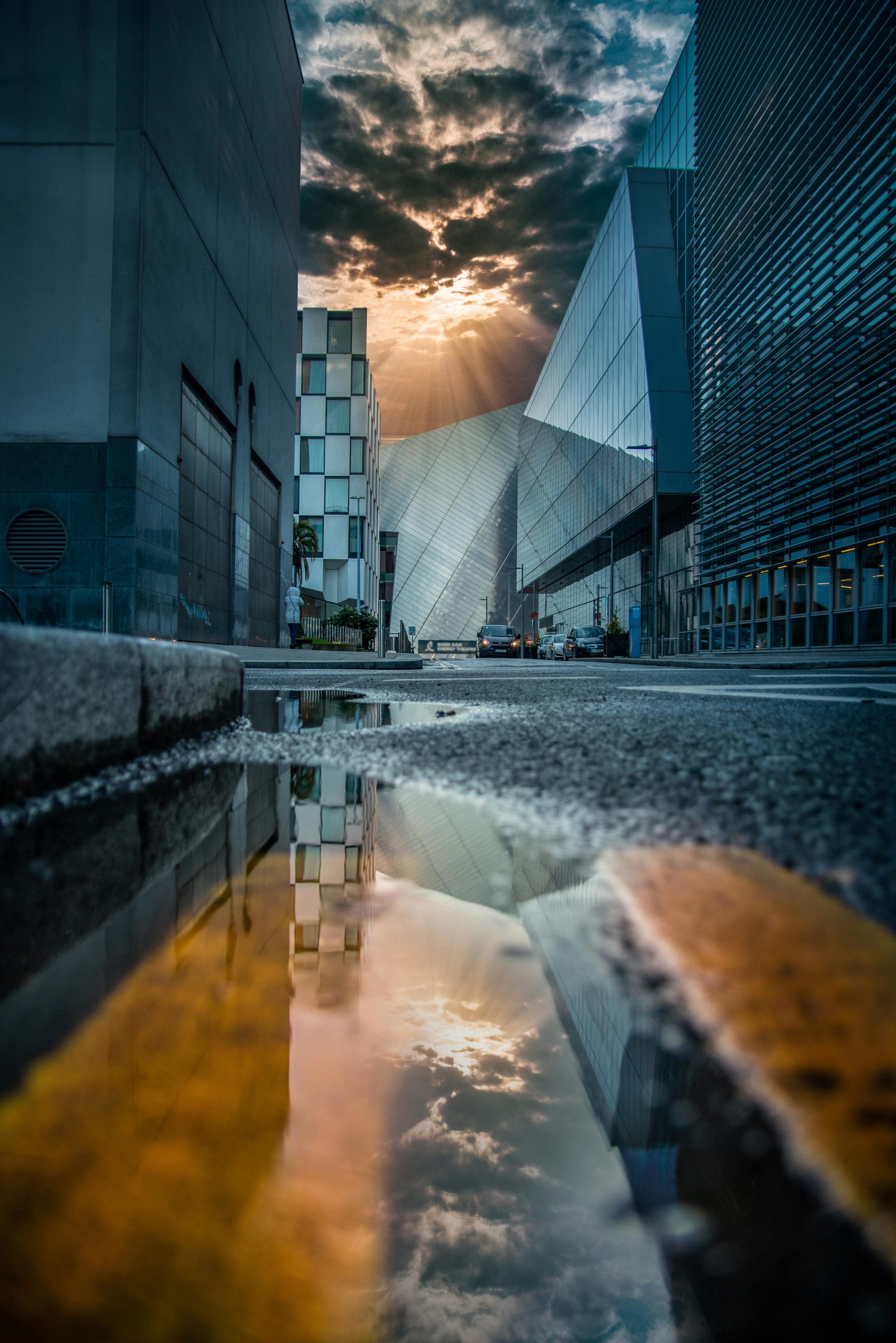 Capturing a striking sunset reflection in a puddle along a modern Dublin street.